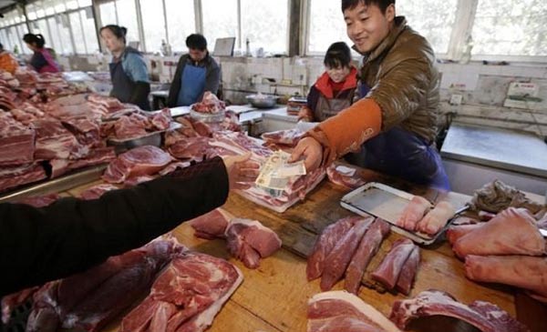 Khách hàng mua thịt heo ở một khu chợ tại Bắc Kinh, Trung Quốc. Ảnh: Reuters