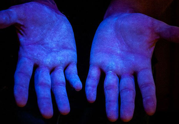 Hình 6: Bột huỳnh quang phát sáng dưới tia UV chứng tỏ đã bao phủ toàn bộ bề mặt tay người. 