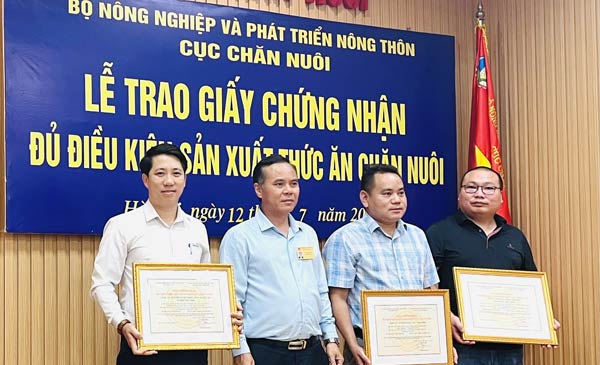 Ông Phạm Kim Đăng, Phó Cục trưởng Cục Chăn nuôi trao giấy chứng nhận đủ điều kiện sản xuất thức ăn chăn nuôi cho các doanh nghiệp. Ảnh: Hồng Thắm